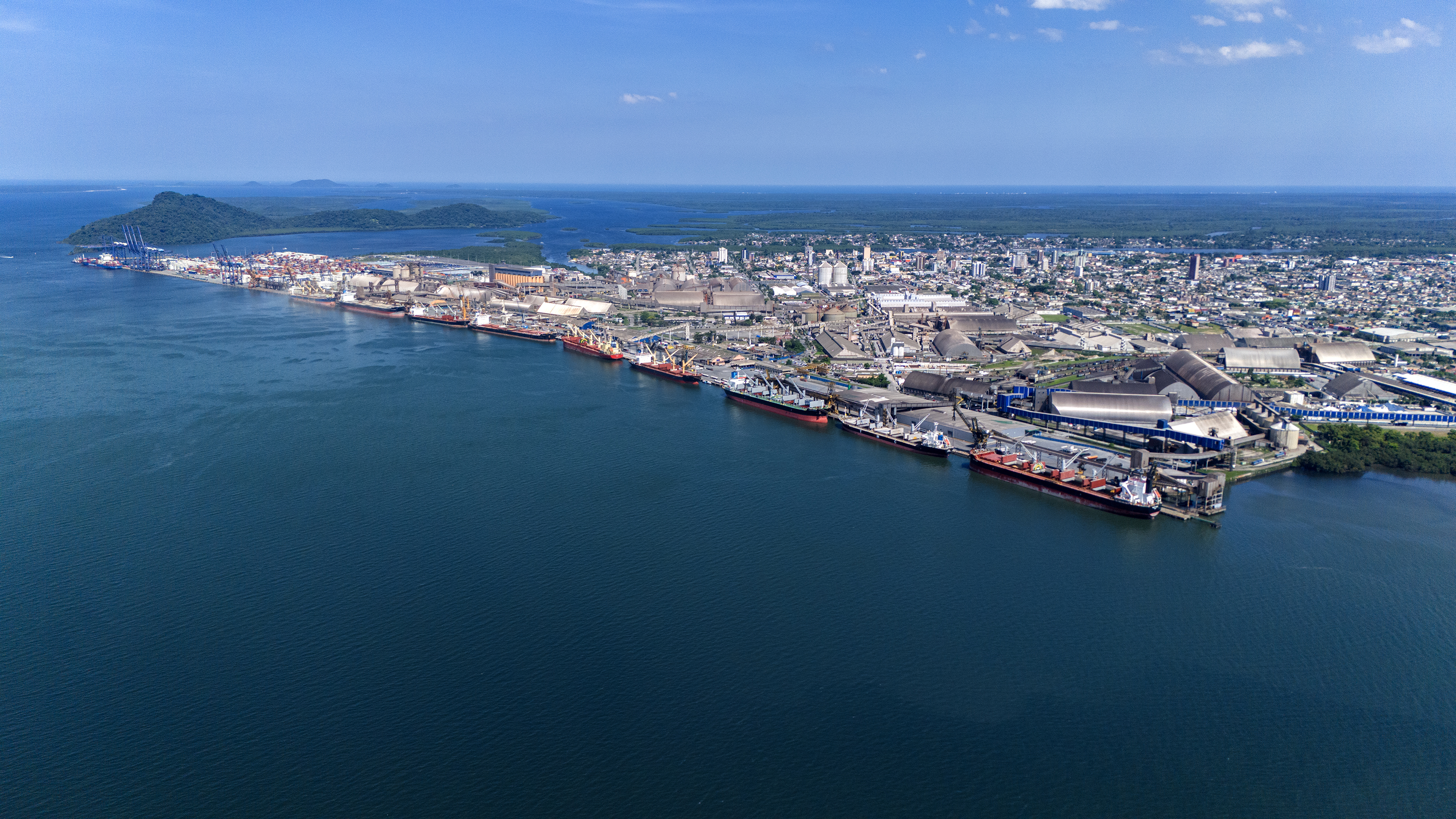 imagem aérea do Porto de Paranaguá em um dia de céu azul, os navios atracados em todo o cais