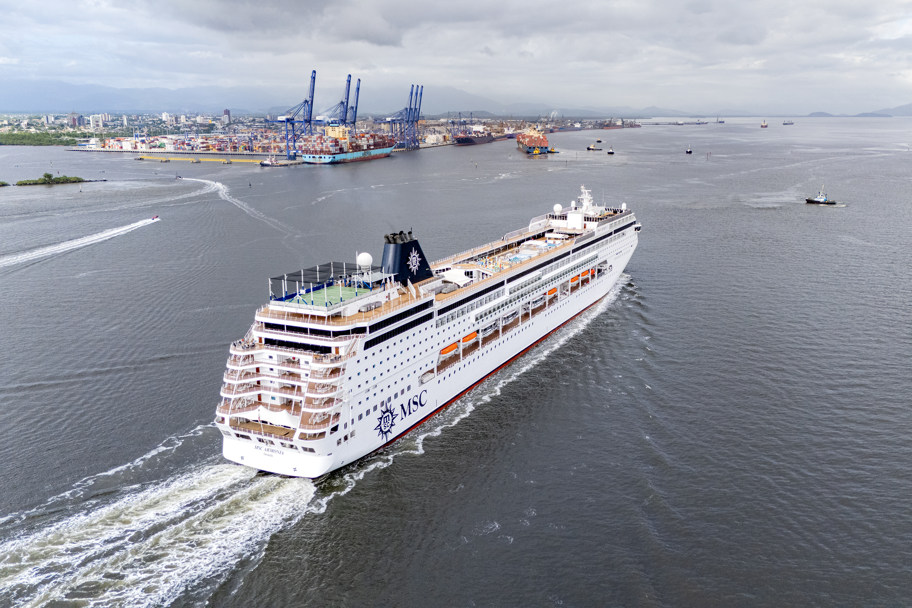 #praquemnaopodever navio de cruzeiros branco cruz a baía de Paranaguá e segue em direção ao Porto de Paranaguá. Ao longe, rebocadores,navios e lanchas cruzam os mares.