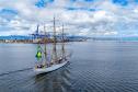 Imagem aérea mostra navio-veleiro cruzando a Baía de Paranaguá em direção ao Porto de Paranaguá, que aparece ao fundo. O céu azul com nuvens e o movimento das ondas tranquilas deixa a imagem ainda mais bonita. #praquemnaopodever