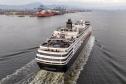 #praquemnaopodever navio de cruzeiros preto e branco cruza a Baía de Paranaguá em direção ao Porto. Na imagem aérea é possível ver o céu nublado e a piscina vazia de um navio que chegou cedo para atracar.