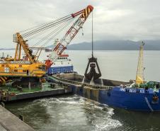 Os berços do Porto de Paranaguá começam a ser dragados por um draga mecânica, nesta sexta-feira (6). Esta é a primeira vez que uma “Clamshell” realiza obras nos portos paranaenses. A diferença entre essa e as embarcações comuns na realização desse serviço marítimo, no Estado, é a precisão e a segurança para dragar mais próximo ao costado.