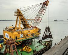 Os berços do Porto de Paranaguá começam a ser dragados por um draga mecânica, nesta sexta-feira (6). Esta é a primeira vez que uma “Clamshell” realiza obras nos portos paranaenses. A diferença entre essa e as embarcações comuns na realização desse serviço marítimo, no Estado, é a precisão e a segurança para dragar mais próximo ao costado.