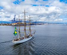 Imagem aérea mostra navio-veleiro cruzando a Baía de Paranaguá em direção ao Porto de Paranaguá, que aparece ao fundo. O céu azul com nuvens e o movimento das ondas tranquilas deixa a imagem ainda mais bonita. #praquemnaopodever