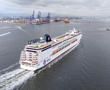 #praquemnaopodever navio de cruzeiros branco cruz a baía de Paranaguá e segue em direção ao Porto de Paranaguá. Ao longe, rebocadores,navios e lanchas cruzam os mares.