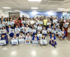 #praquemnaopodever Na recepção da Portos do Paraná, dezenas de crianças estão posicionadas segurando uma placa em homenagem ao prêmio do Concurso de Desenho do Porto Escola. Professores, pais, representantes dos municípios e da Portos do Paraná também estão na foto.