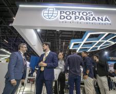 dois homens cnversam em frente ao estande da Intermodal no evento. Ao fundo pessoas circulam plo estande.