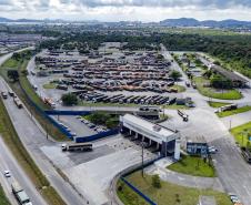 #praquemnaopodever imagem aérea do patio de triagem mostra a entrada do pátio de triagem, uma br com quase nenhum movimento e muitos caminhões estacionados ao fundo