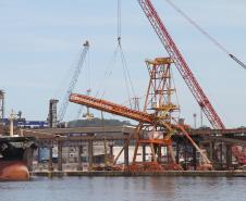 Um dos quatro novos shiploaders do Corredor de Exportação do Porto de Paranaguá fica pronto no final deste mês. O equipamento está com a parte elétrica bastante adiantada e acaba de receber a lança, parte que avança sobre o porão do navio para o carregamento dos grãos. Os próximos passos serão a conexão na estrutura já existente no cais, correias transportadoras e ligações elétricas.

