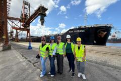 #praquemnaopodever cinco mulheres posam lado a lado no cais do Porto de Santos. Trajando coletes amarelos luminescentes, camisas por baixo e calças jeans, todas estão com capacetes e sorriem para a foto.