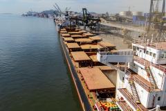 #praquemnaopodever foto aérea do cais do Porto de Paranaguá, na ponta direita está o navio graneleiro com todos os porões carregados de soja. O céu está azul e o cais está lotado de embarcações.