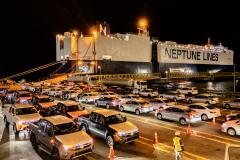 #praquemnaopodever imagem aérea da ponta do cais, onde os carros estacionados aguardam os motoristas para seguirem em direção ao patio. É noite, o navio metade preto e metade azul está com as luzes amarelas acesas.