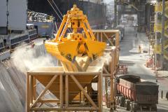 #praquemnaopodever imagem de cima mostrando um gancho amarelo gigante soltando cevada, que são graos amarelos, em um funil.