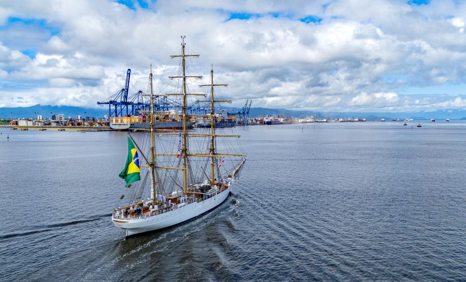 Imagem aérea mostra navio-veleiro cruzando a Baía de Paranaguá em direção ao Porto de Paranaguá, que aparece ao fundo. O céu azul com nuvens e o movimento das ondas tranquilas deixa a imagem ainda mais bonita. #praquemnaopodever