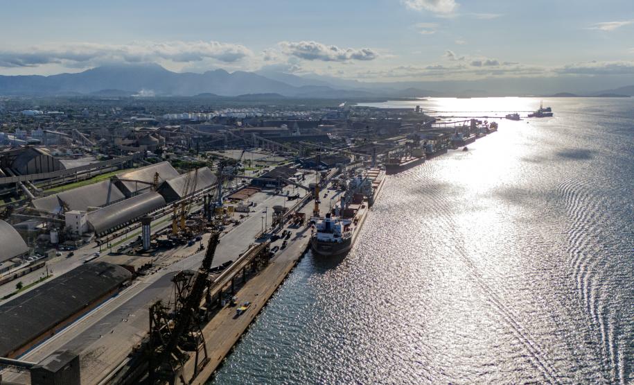 Imagem aérea do Porto de Paranaguá mostrando o cais contra a luz enquanto os navios operam.