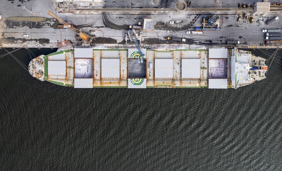 #praquemnaopodever navio visto de cima, mostra três dos sete porões abertos. Dois deles, um em cada extremidade, estão lotados de sacos brancos. O porão do meio tem um grande volume de pó cinza. Toda a carga de navio é de fertilizantes, que estão sendo importados para diversos estados brasileiros.