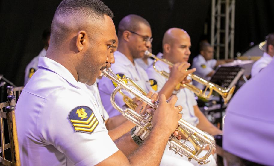 #praquemnaopodever musicistas de branco sentados em cadeiras de madeira aparecem de lado tocando concentrados os instrumentos.