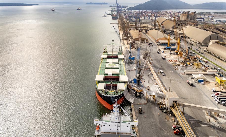 #praquemnaopodever imagem aérea do navio verde com três poroes abertos e operando bags de fertilizantes. Metade da foto é baía de Paranaguá e outra metade é cais do Porto de Paranaguá