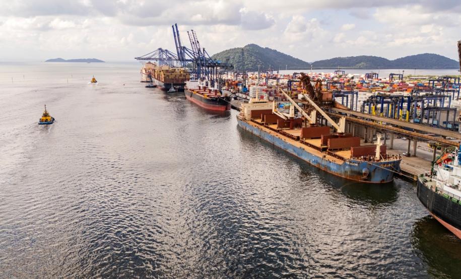#praquemnaopodever imagem aérea do cais do Porto, mostrando as águas da baía de paranagua sob um céu azul e um cais cheio de meganavios