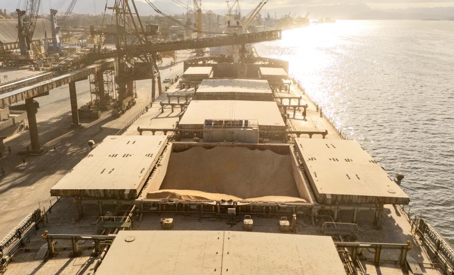 #praquemnaopodever imagem aérea de um navio no fim de tarde, no contraluz, em tom marrom e repleto de carga de milho em um dos porões.