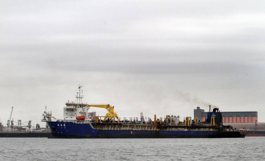 Chega a Paranaguá equipamento que fará a dragagem do canal de acesso aos portos paranaenses A draga utiliza um sistema de dutos que são baixados até o fundo do canal e fazem a sucção do material a ser dragado. Tudo é comportado nos porões da embarcação, que tem uma capacidade de cisterna de 17 mil metros cúbicos. Uma vez cheia, a draga viaja até a área de despejo e abre a cisterna para depositar o material recolhido. Trabalham a bordo da draga 32 pessoas, entre as quais 12 brasileiros.