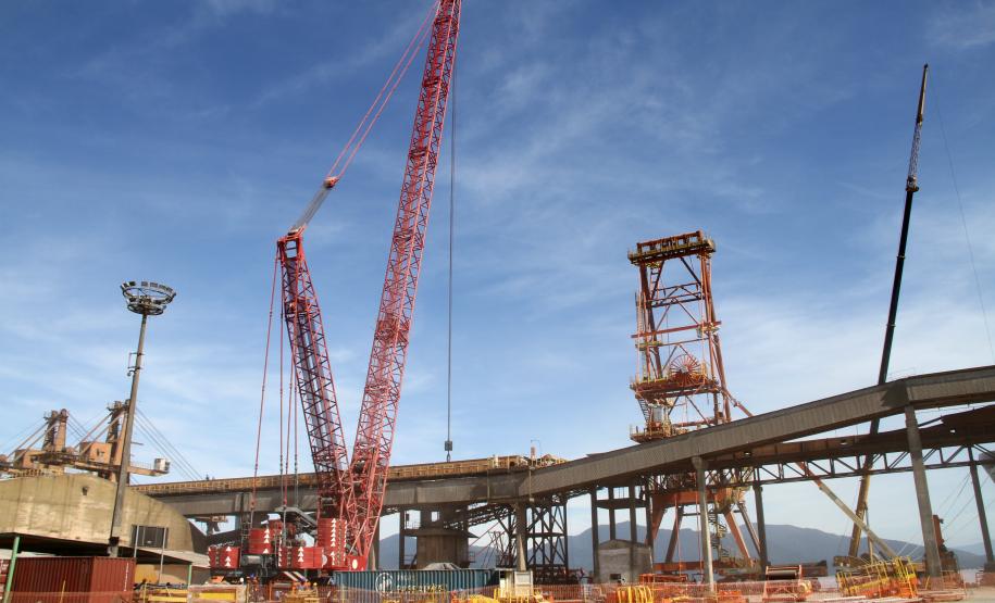 A estrutura montada, em frente ao berço 213, para a instalação da lança do equipamento, esta semana, chamou a atenção dos trabalhadores do cais. Para conseguir içar a peça – que pesa mais de 52 toneladas e mede 45 metros de comprimento, tem seis metros de largura máxima e 3,15 de altura – foi preciso reforço.